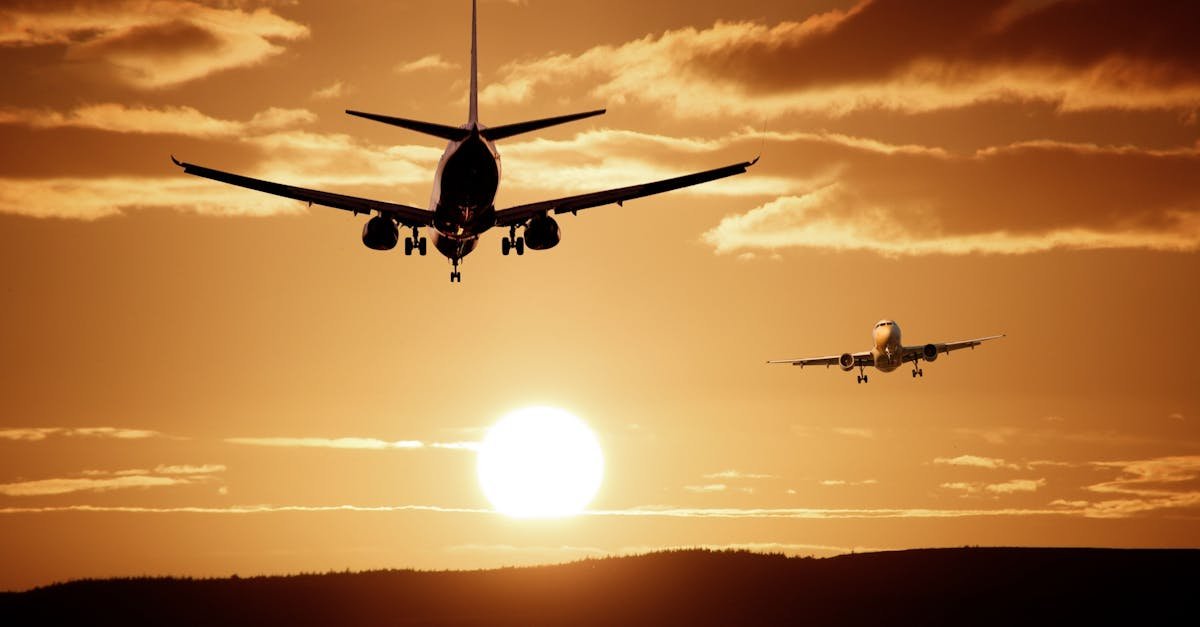 Silhouetted airplanes landing against a dramatic sunset sky, capturing the essence of flight.