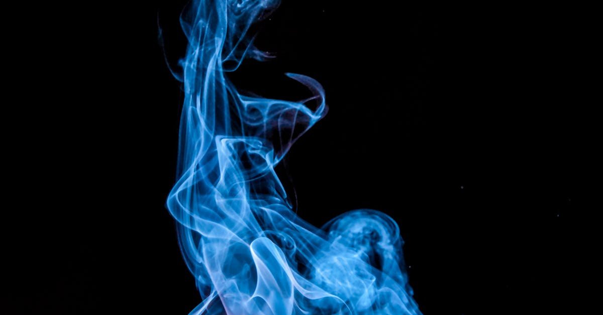 A match ignites with vibrant blue smoke against a black background.