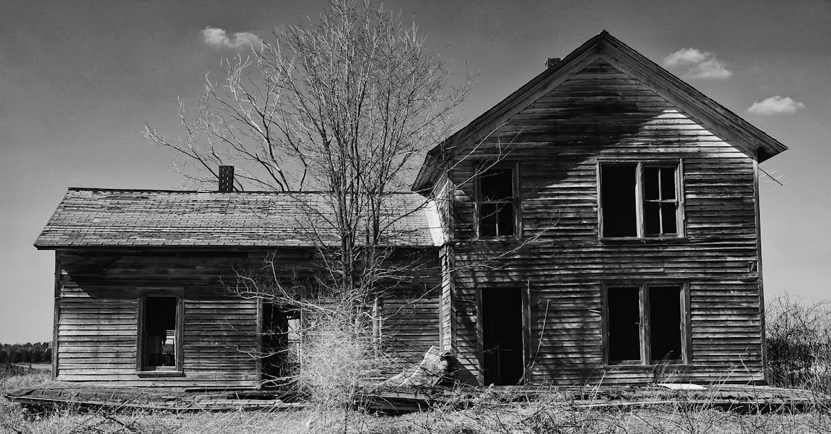 Black and white photo of an old, dilapidated wooden house in rural Marshfield WI.