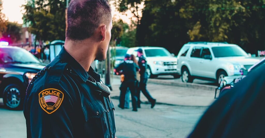 Police officer monitoring a street scene with patrol vehicles in Wheeling, WV.
