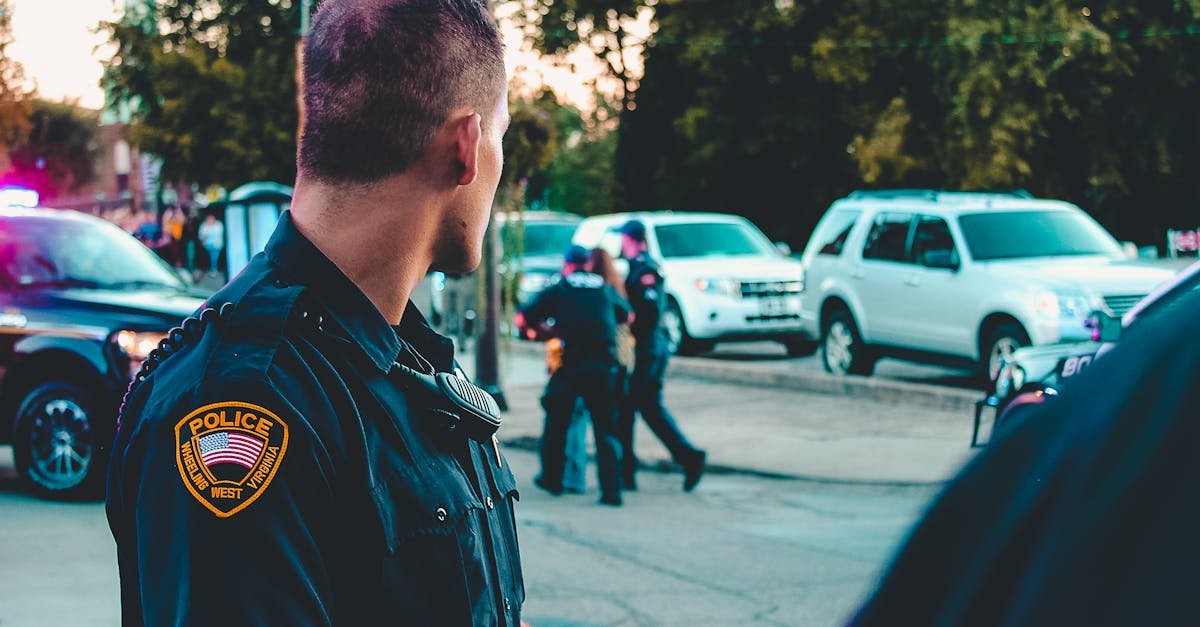 Police officer monitoring a street scene with patrol vehicles in Wheeling, WV.