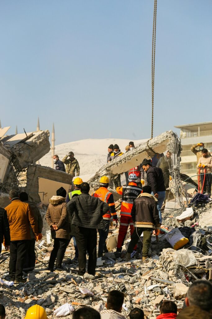 Rescue workers and civilians gathered on rubble after a devastating earthquake in Kahramanmaraş, Türkiye.