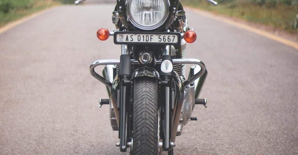 A classic vintage motorcycle parked on a quiet rural road surrounded by lush greenery.
