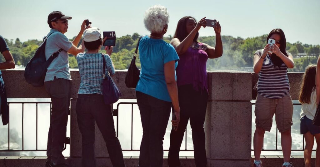 Group of diverse tourists using smartphones to capture scenic outdoor views on a sunny day.