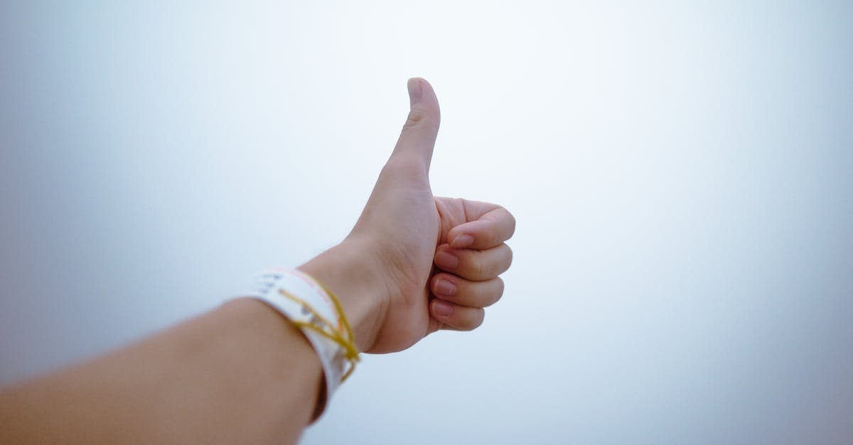 A hand giving a thumbs up gesture symbolizes approval and positivity.