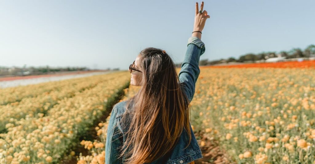 A woman enjoying a sunny day in a vivid yellow flower field in Carlsbad, CA.
