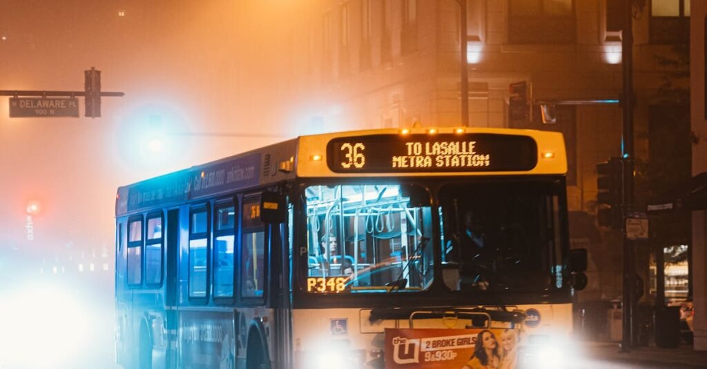 City bus on a foggy Chicago night with illuminated street and traffic lights.