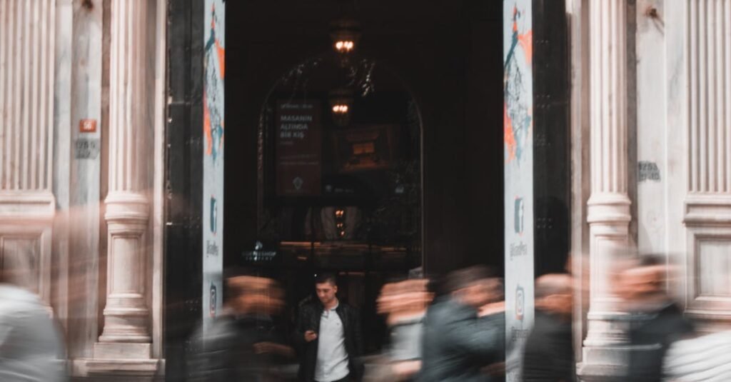 Dynamic urban scene capturing motion at Grand Pera entrance in Istanbul's bustling Beyoğlu district.