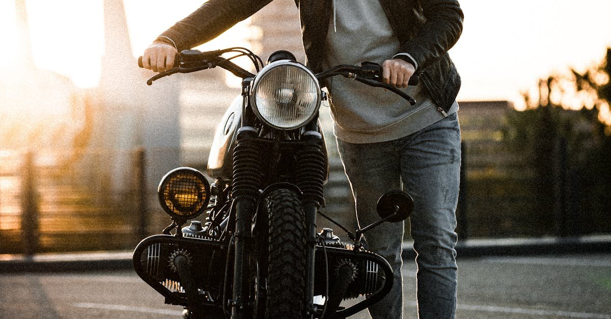 A man in casual wear stands by his motorcycle during sunset in Eindhoven.