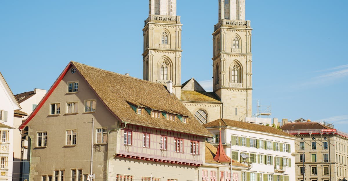 A scenic view of Grossmünster Church with its iconic towers in Zurich, Switzerland by the river.