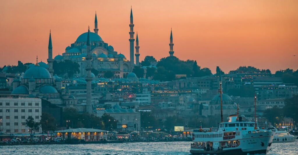 A stunning cityscape of Istanbul at sunset featuring the iconic Suleymaniye Mosque and bustling Bosphorus ferry.