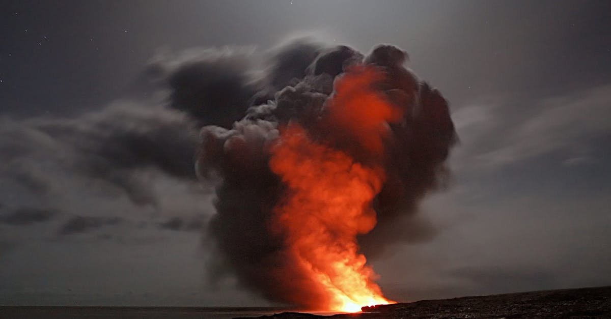 Volcanic eruption with smoke and lava under a starry night sky.