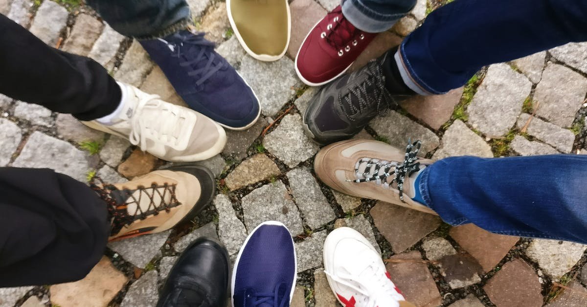 Circle of sneakers on cobblestone pavement representing diversity and urban fashion.