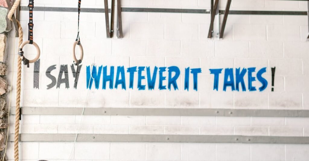 Athlete exercising indoors in gym with motivational wall text.