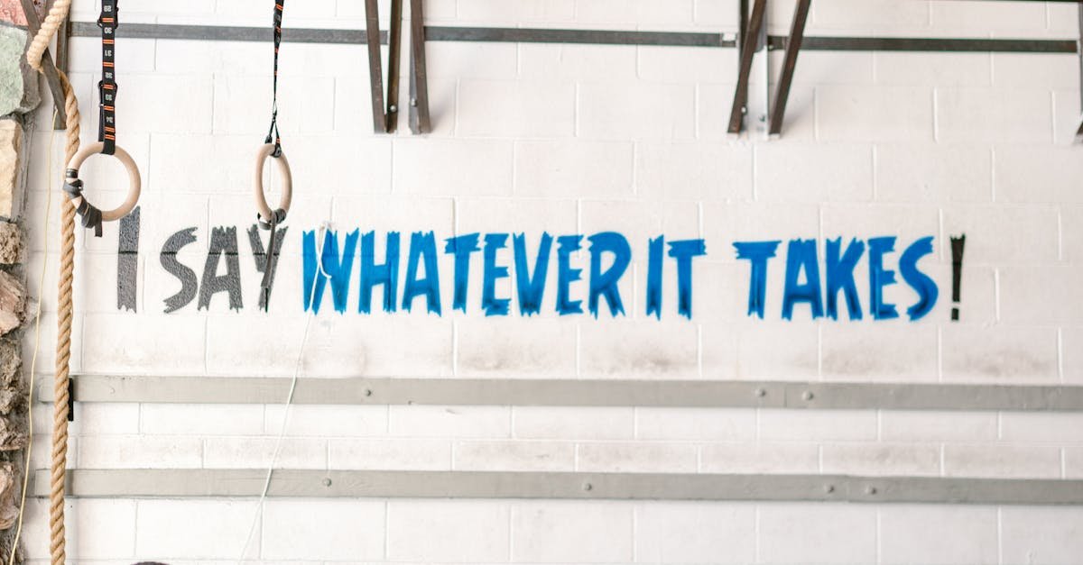 Athlete exercising indoors in gym with motivational wall text.