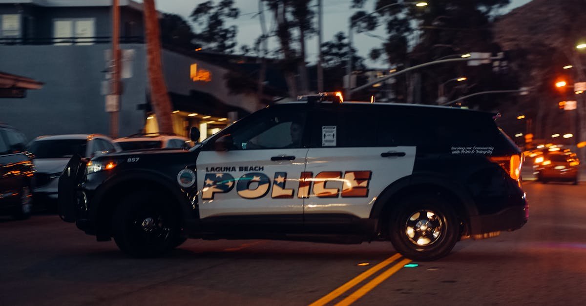 Laguna Beach police vehicle patrols the street at night, showcasing law enforcement presence.