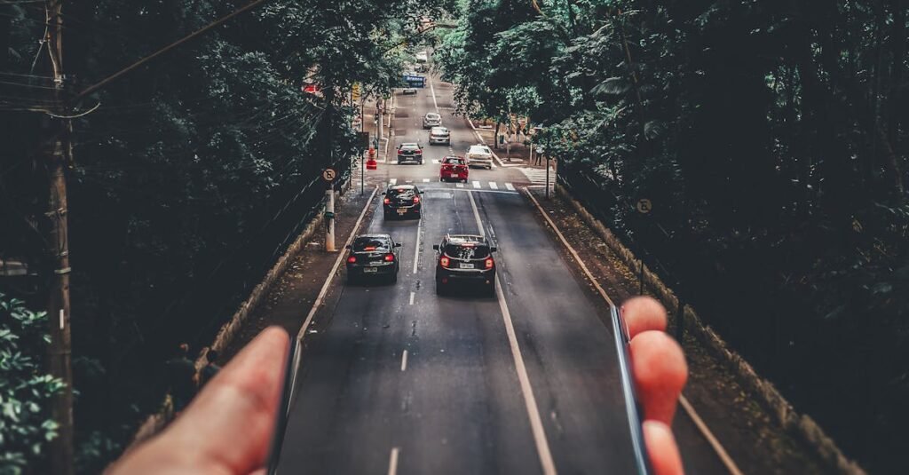 Creative blend of technology and nature with smartphone framing a bustling road through forest.