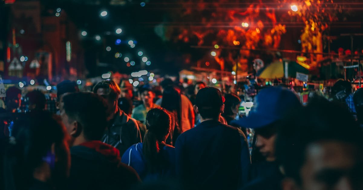 A bustling street market at night with crowds and vibrant streetlights.