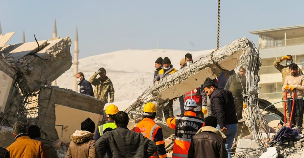 Rescue workers and civilians gathered on rubble after a devastating earthquake in Kahramanmaraş, Türkiye.