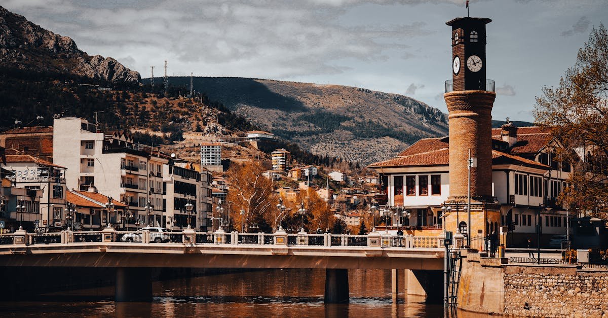 Scenic view of the Amasya clock tower and bridge over a river with mountainous backdrop in Turkey.