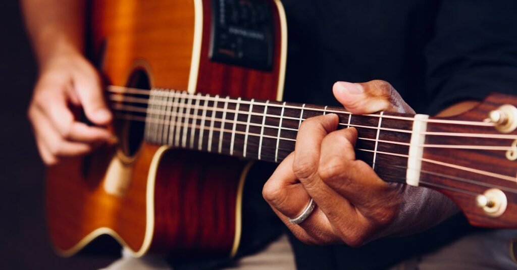 Hands playing an acoustic guitar, showcasing chords and frets up close.