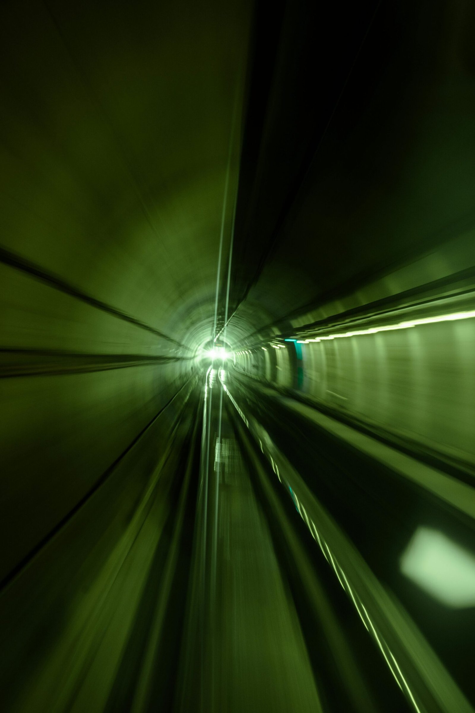 Blurred motion in a green-lit subway tunnel in Istanbul, Türkiye.