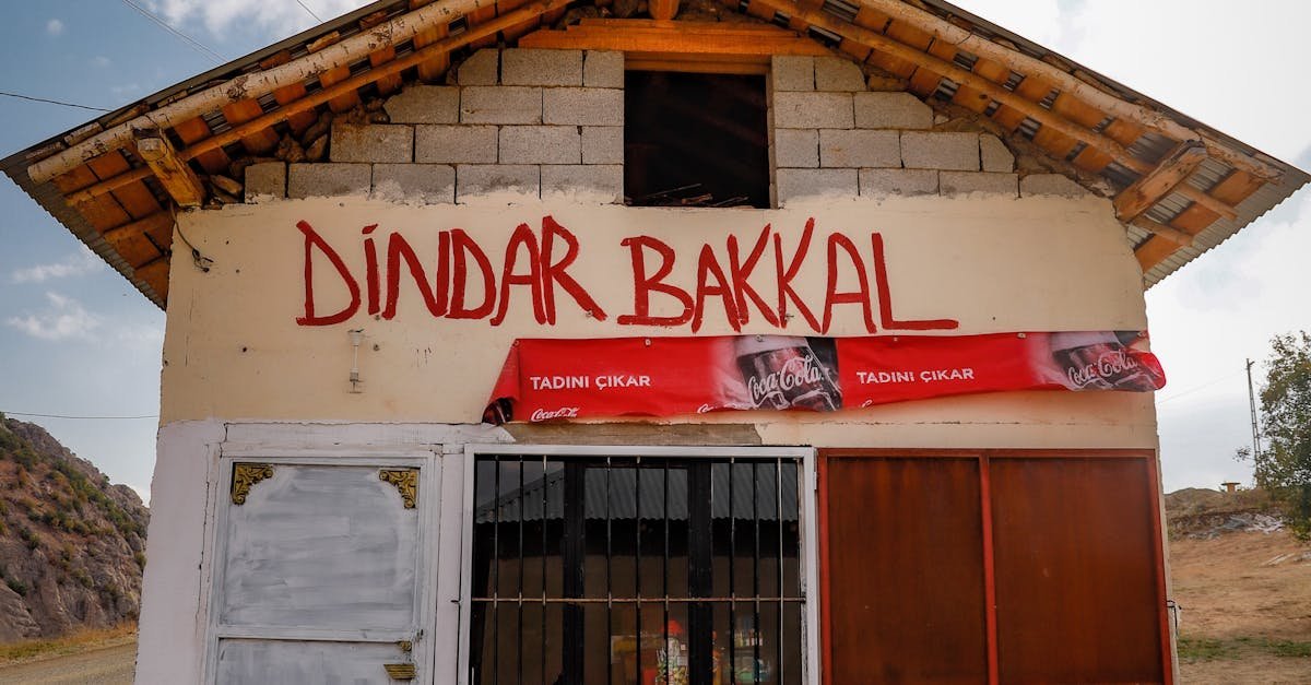 A charming rural market building with a rustic facade in Hakkâri, Türkiye, set against a cloudy sky.