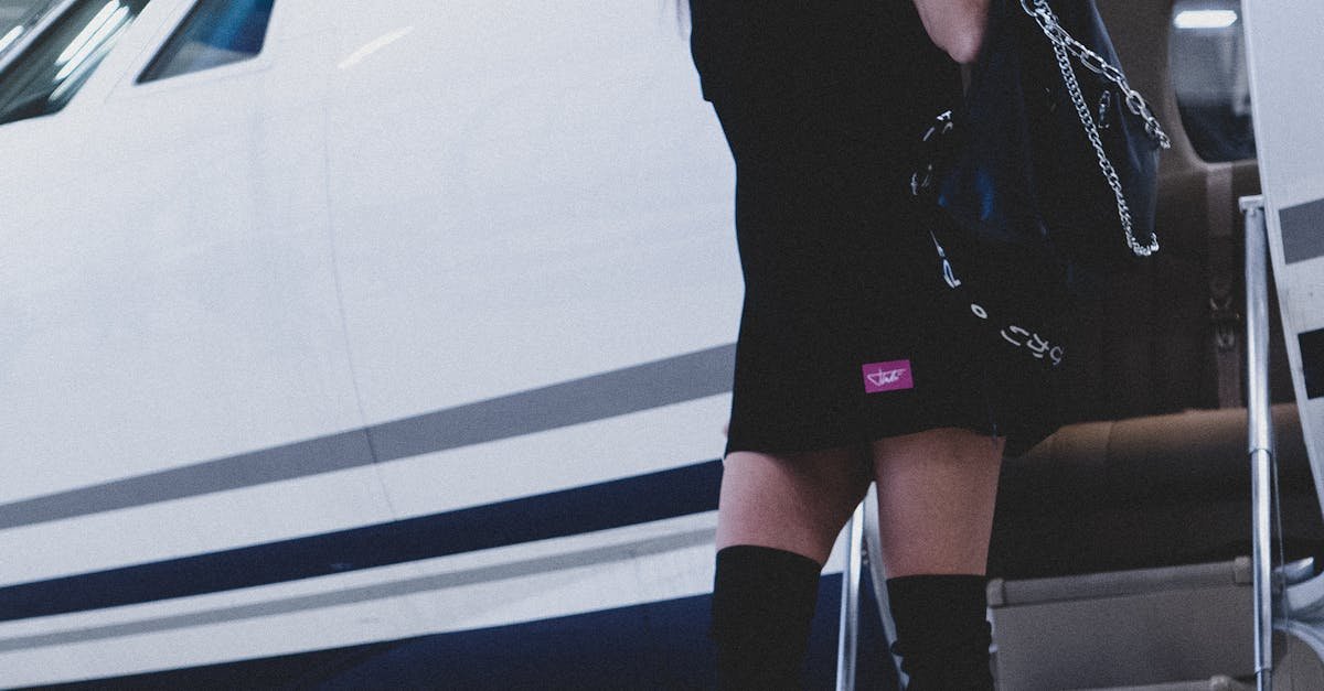 A fashionable woman in boots descends from a luxury private jet, exuding sophistication and wealth.