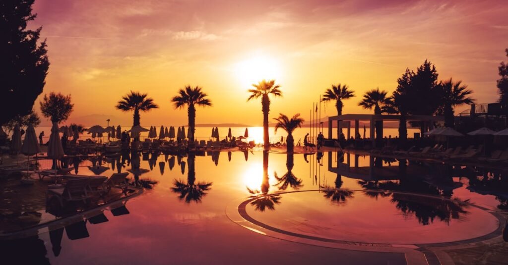 Idyllic sunset view over a tranquil pool with palm trees in Bodrum, enhancing a serene vacation vibe.