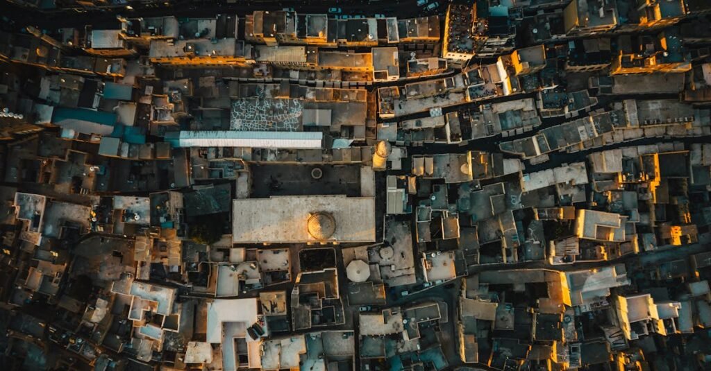 Drone shot over Mardin, Turkey, showcasing historic stone architecture under warm sunlight.