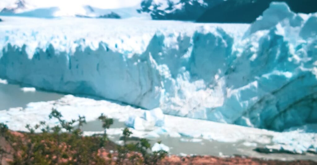 A hand holds a mate cup beside the stunning Perito Moreno Glacier in Patagonia.