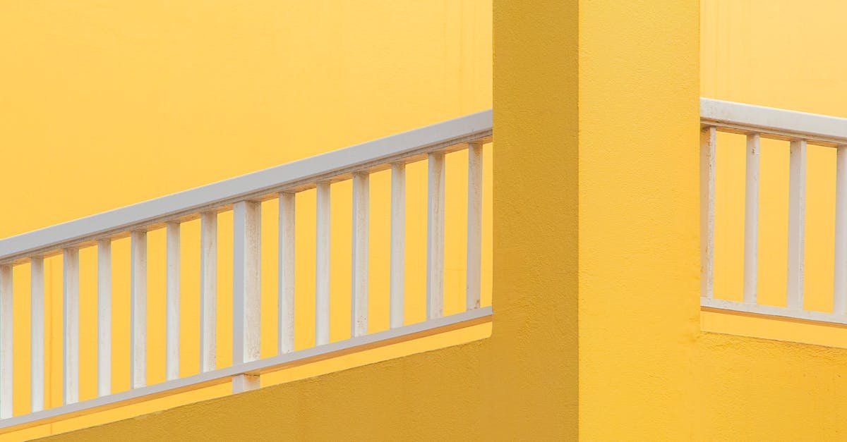 A vibrant minimalist composition showcasing a yellow wall and white balustrade.