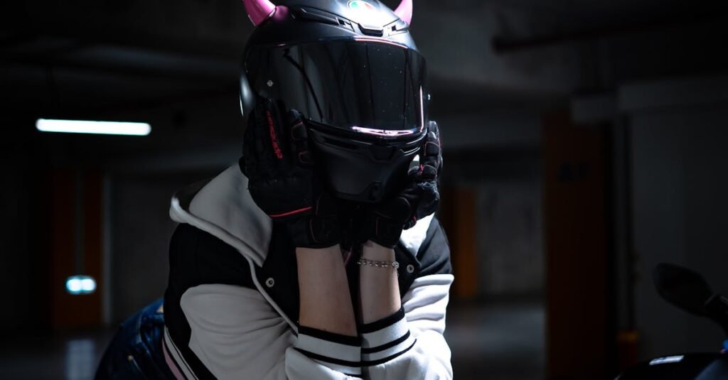 Mystery biker with devil horns helmet in dimly lit garage.