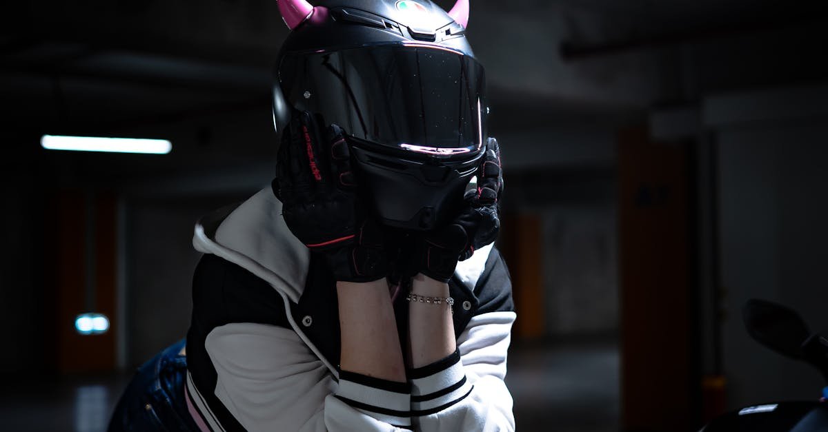 Mystery biker with devil horns helmet in dimly lit garage.