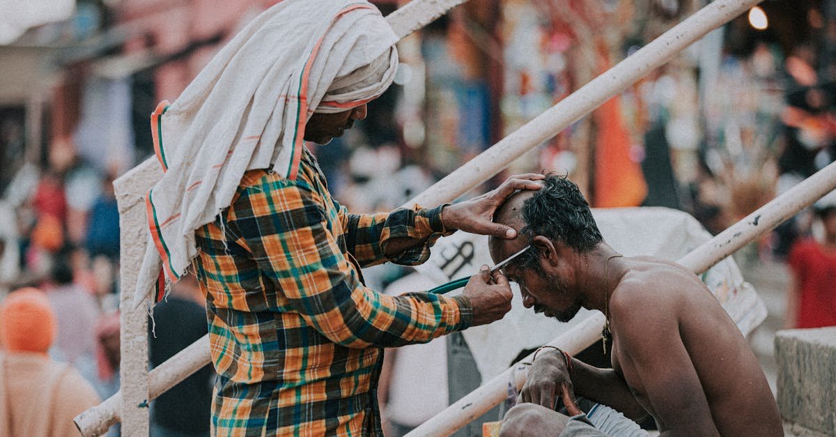 A local street barber giving a haircut by the Ganges River in Varanasi, India.