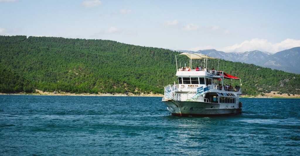A tour boat cruising on a picturesque lake with lush green hills in Samsun, Türkiye.