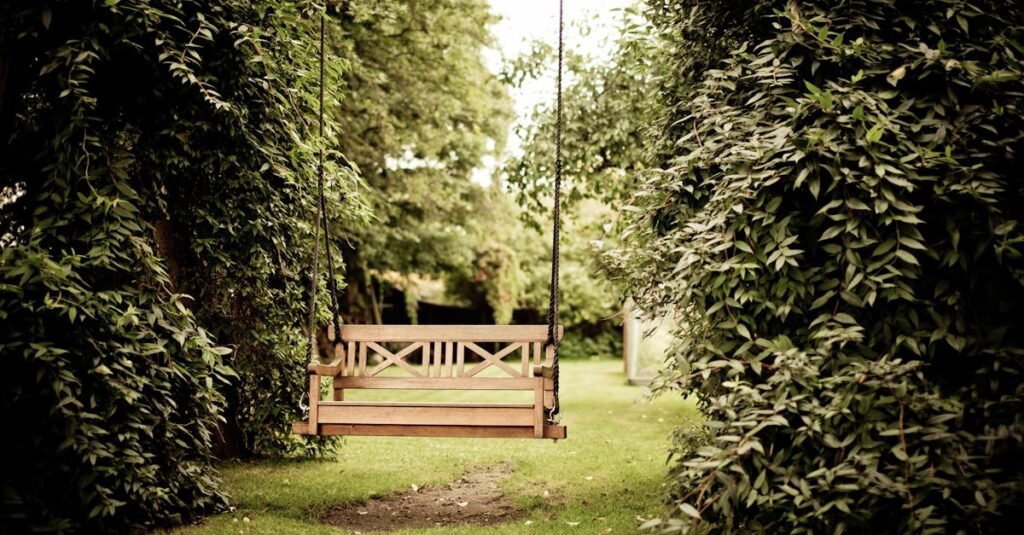 A tranquil wooden swing hanging in a verdant garden setting, ideal for relaxation.
