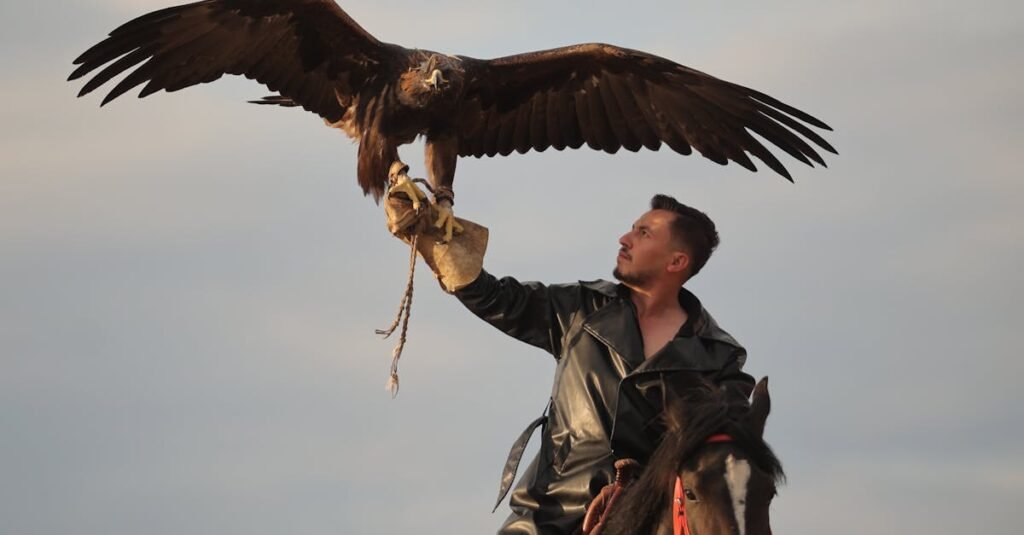 A Kyrgyz eagle hunter on horseback with a trained golden eagle in the mountains.