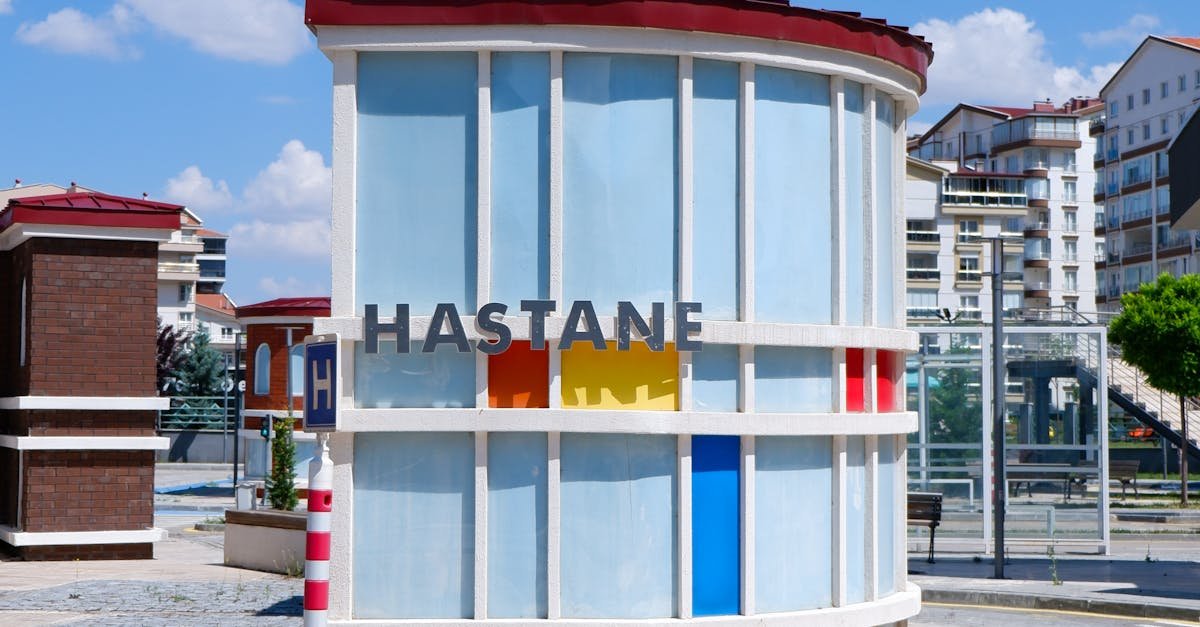 Contemporary circular hospital sign in Ankara with vibrant colors under a clear blue sky.