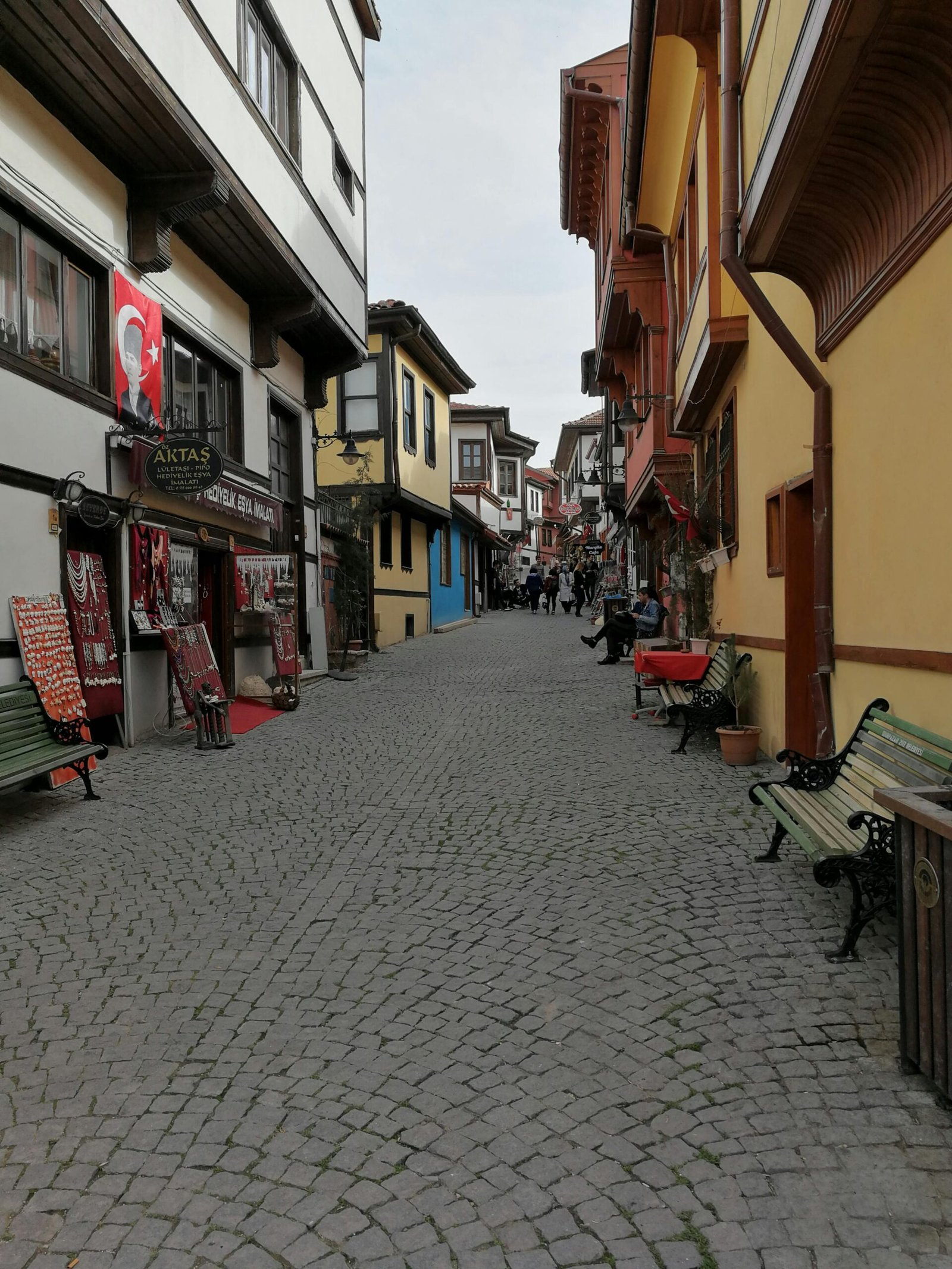 Explore a picturesque cobblestone street in Eskişehir, Turkey, lined with colorful buildings.