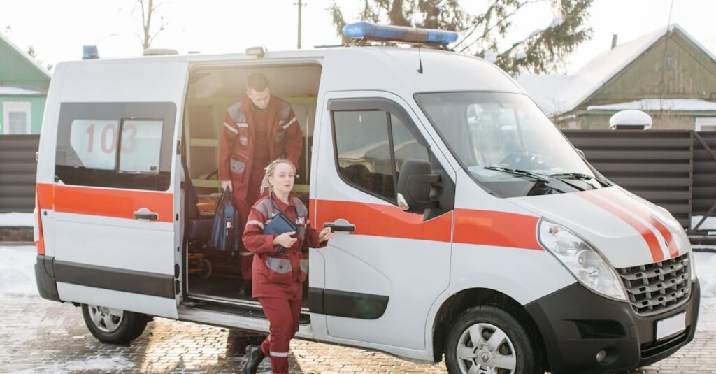 Paramedics stepping out of an ambulance with equipment on a snowy outdoor scene.