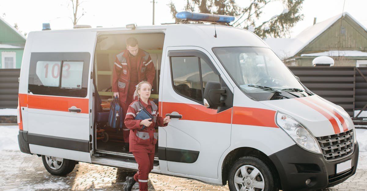 Paramedics stepping out of an ambulance with equipment on a snowy outdoor scene.