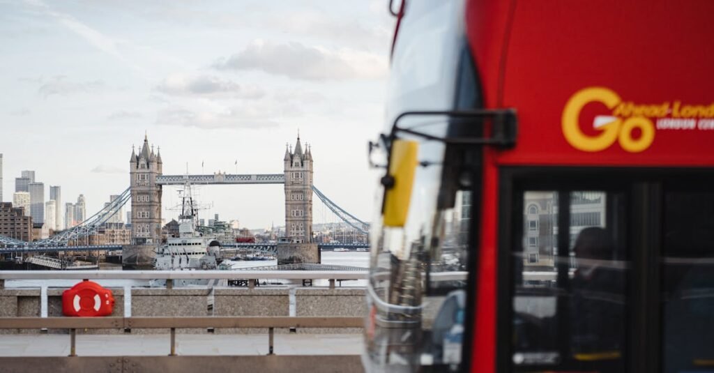 Iconic Tower Bridge in London with a red bus passing by on a clear day.