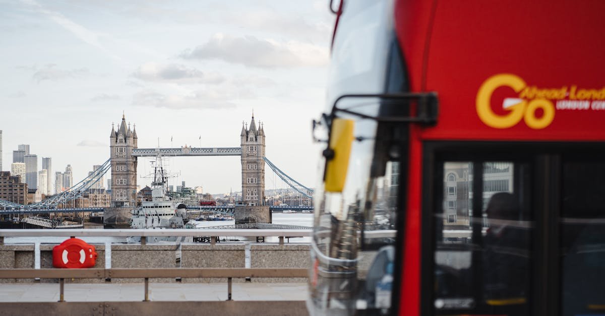 Iconic Tower Bridge in London with a red bus passing by on a clear day.