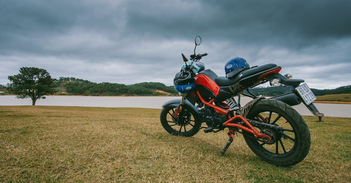 A scenic view of a parked motorcycle near a calm lake under stormy clouds, capturing the essence of adventure and nature.