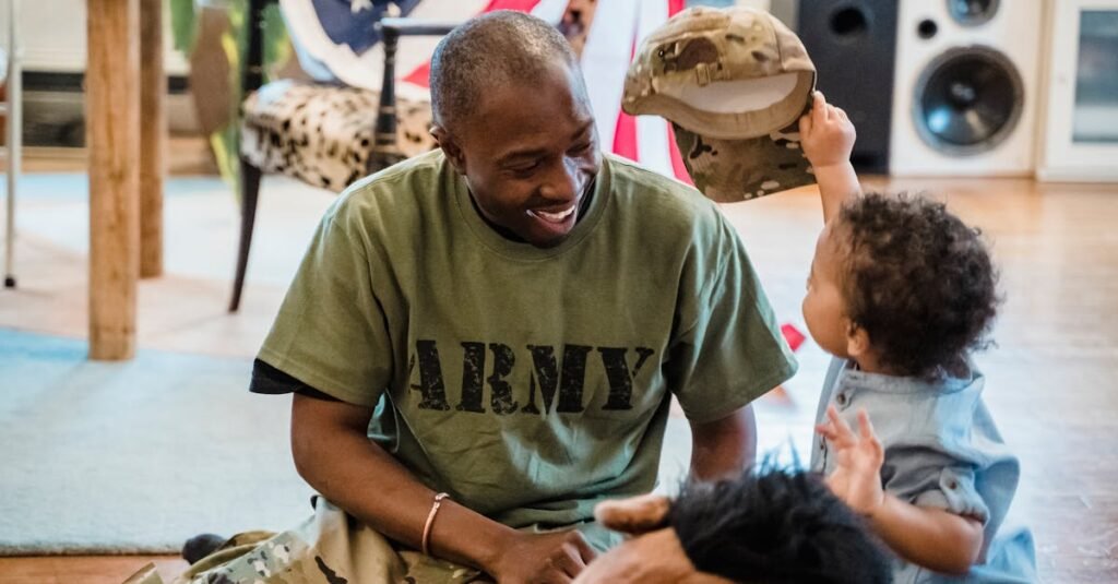 Father and young son enjoying quality time indoors with army apparel, sharing joy and love.