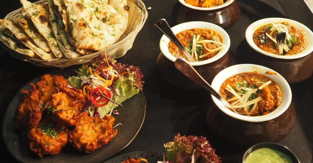 A mouth-watering display of Indian cuisine featuring naan, curry, and pakoras perfect for a delightful meal.