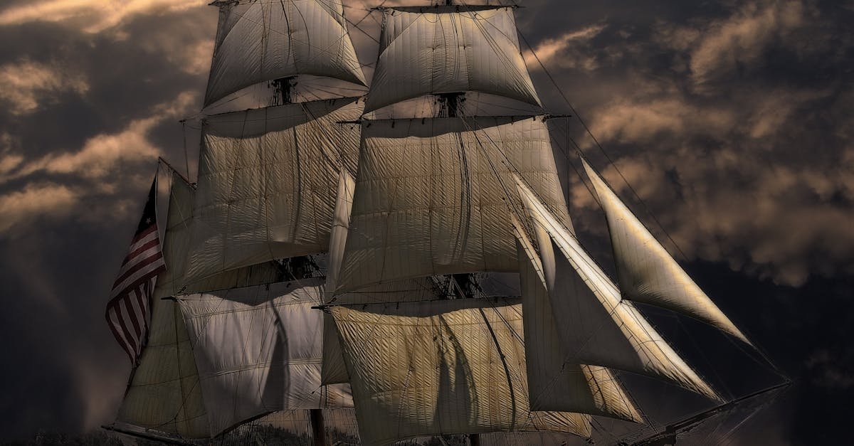 A majestic sailing ship with white sails against a dark, stormy sky, evoking a sense of adventure.
