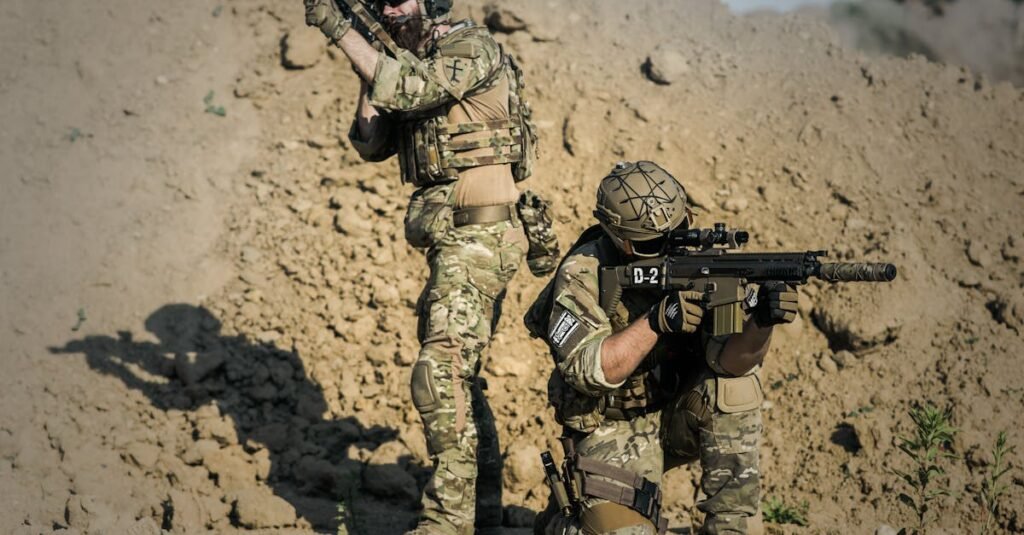 Two soldiers in camo engage in tactical training in a desert environment.