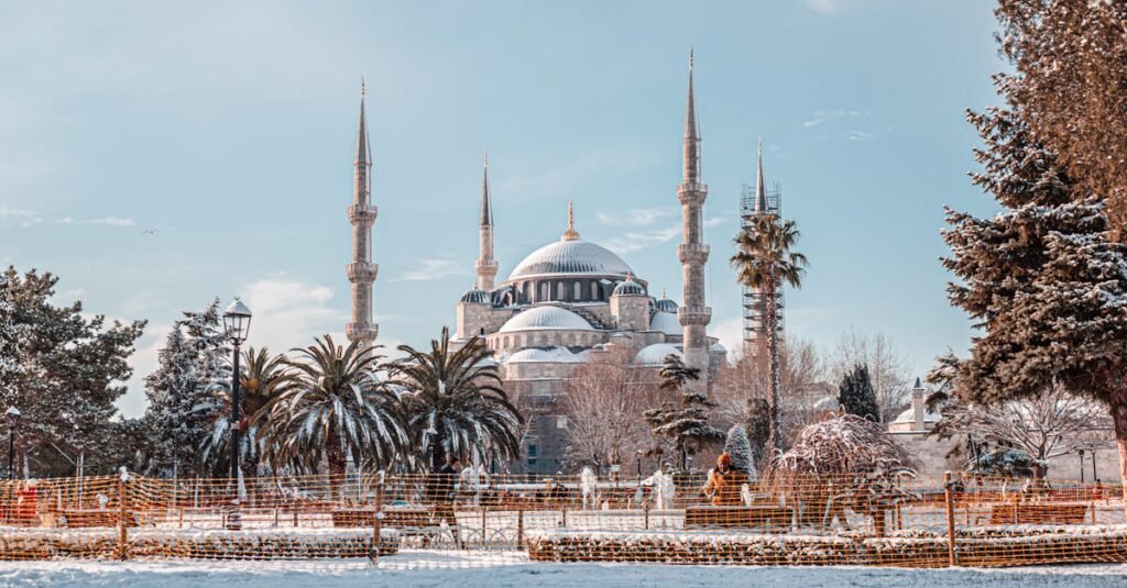 A captivating winter scene of the Sultan Ahmed Mosque in Istanbul, Turkey, with snow-covered ground and clear blue sky.